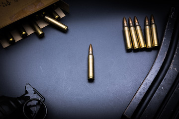 Rifle cartridges 5.56 mm and magazine on a black background