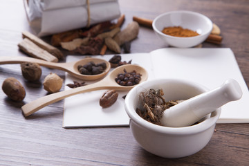 White mortar and herbal medicine on the wood table with studio light