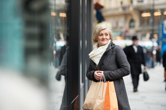 Beautiful Senior Woman Window Shopping In The City. Winter