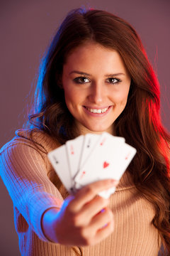 Beautiful brunette holding four aces as a sign for poker game, gambling and casino