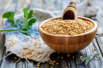 Oats and wooden scoop in a bowl.