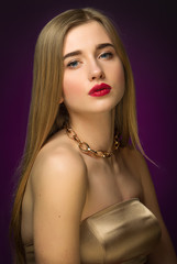 Blonde girl in gold. Classic portrait. Blue eyes and red lips