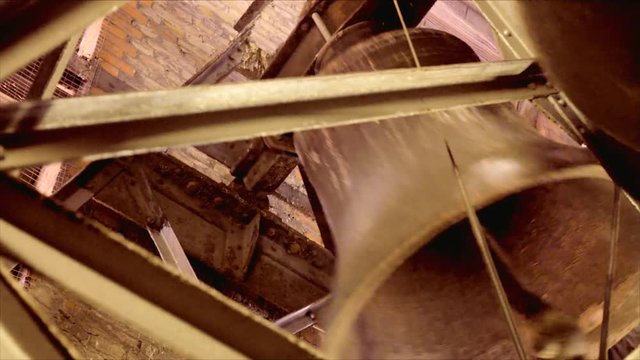In an Old Church at the Belfry a smal Bell is Ringing 2, The belfry is made out bricks and steel.