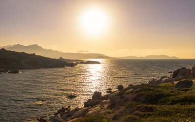 Fototapeta premium Sun setting over a Genoese tower and Calvi in Corsica