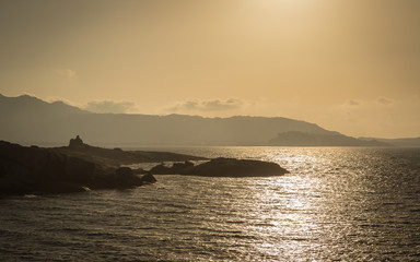 Sun setting over a Genoese tower and Calvi in Corsica
