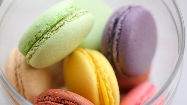 Close-up of colorful macaron (macaroon). Colorful French macarons or macaroons, gourmet dessert closeup loop. Colorful macaroons on showcase in a fancy cafe. 