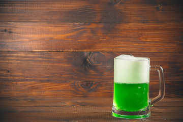 St Patrick's Day concept mug green beer against wooden background