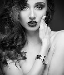 Obraz premium Glamour elgant womanwith professional make up, curly hail and fashion watches on her arm.