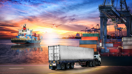 Logistics import export background and transport industry of Container truck and Cargo ship with working crane bridge in shipyard at sunset sky