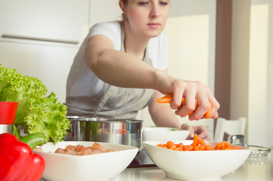 Woman takes carrots to prepare a meal. Conception of healthy nutrition.