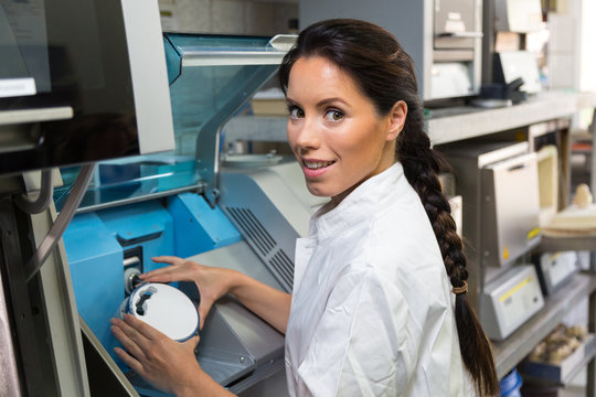 Dental technician puts ceramics implant in milling machine