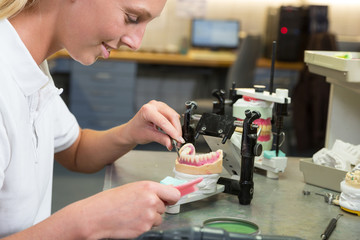 Technician working on a dental implant in articulator