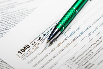 Fototapeta premium US tax form 1040 with pen and calculator. Tax form law document, business concept