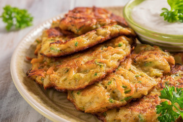 Naklejka premium Vegetable fritters with potato, carrot, zucchini served with Ranch sauce.
