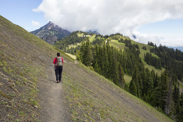 Fototapeta na wymiar Female hiker on steep mountain ridge trail