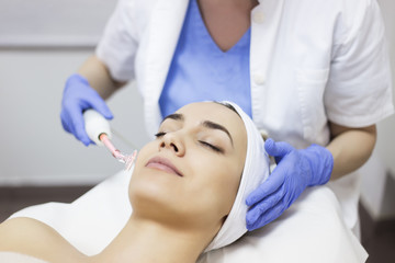 Obraz na płótnie Canvas Skin care. Young woman receiving facial beauty treatment. Facial therapy. Anti-aging procedures.