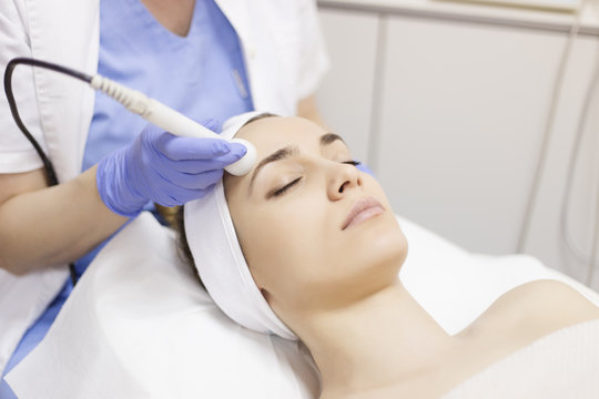 Skin care. Young woman receiving facial beauty treatment. Facial therapy. Anti-aging procedures.