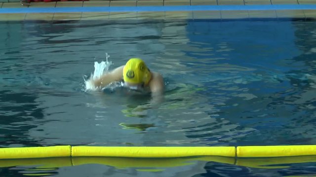 Underwater fighter in yellow cap before the start of the match.
