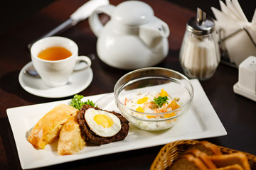 fied egg on meat with salad on plate