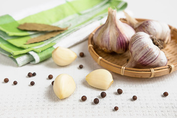 Fresh garlic, onion and spices on a light background closeup