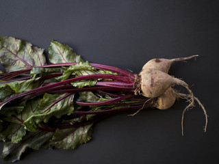 Organic beetroots with leaves isolated on black background