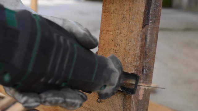 Carpenter cutting wood with reciprocating saw