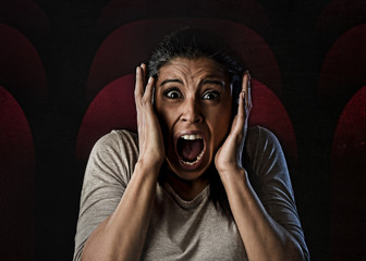 Fototapeta premium woman desperate and scared terrorized at cinema hall watching horror movie