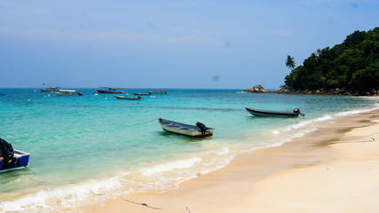 White sand beach with blue water and boats