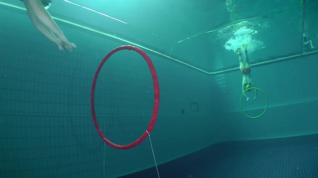 Two underwater fighters swim through the rings and starts duel.
