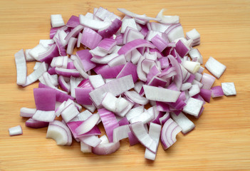 Sliced red onions on cutting wooden board background