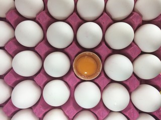 koli içindeki beyaz yumurtalar ve ortasında kırık yumurta