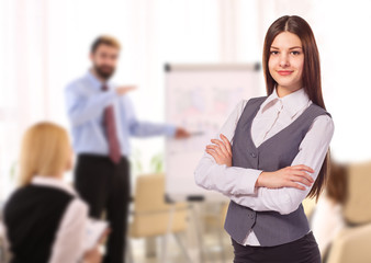 Young smiling woman with arm folded in office