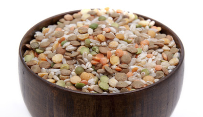 The mixture of different lentils and rice in a wooden bowl