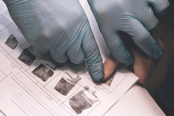 Expert takes a fingerprint of the suspect
