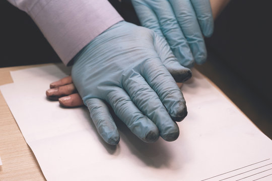 The police officer takes a fingerprint of the suspect in the crime. Investigation of the crime. Guilty of an offense is subject to a policeman's request.