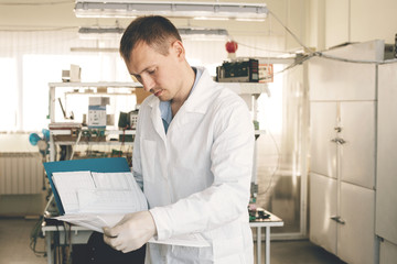 A man in a white coat examines the startup project. Start your own business in a small workplace. 