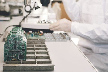 Technician with computer circuit board with chips. Spare parts and components for computer equipment. Production of electronics and maintenance. The concept of high technology.