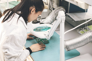 Beautiful female computer expert professional technician examining board computer in a laboratory...