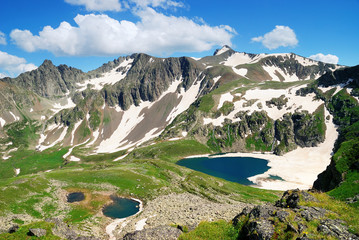 Obraz premium Mountain Lake with clean water and ice in the Caucasus summer. Blue sky with white clouds.
