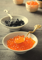 Black and red caviar tartlets, appetizer canapes in white bowls