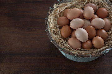 Top View of Fresh Farm Chicken Eggs in Wire Metal Basket on Dark Brown Wooden Table Horizontal with Copy Space