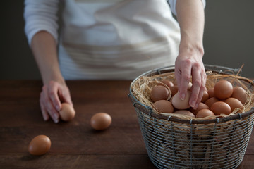 Woman Taking Fresh Farm Chicken Eggs From Wire Basket