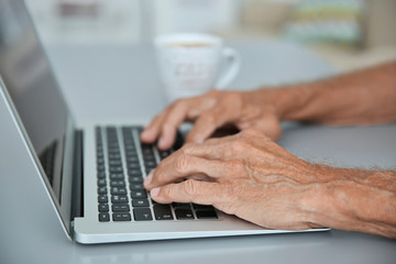 Male hands typing on laptop, closeup