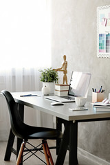 Workplace with laptop on table in modern room