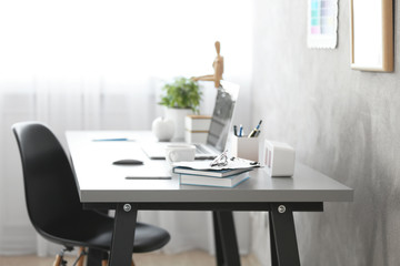 Workplace with laptop on table in modern room