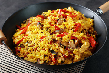 Tasty rice with vegetables in frying pan, closeup