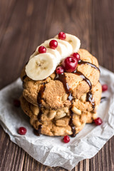 Peanut cookies with banana and berries on a wooden background