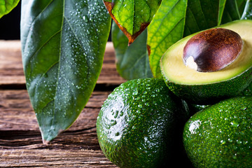 Fresh organic avocado on old wooden table. The composition of pictures in close-up.