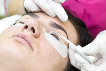 Woman on the procedure for eyelash extensions, eyelashes lamination 