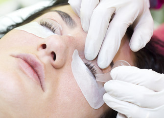 Woman on the procedure for eyelash extensions, eyelashes lamination 